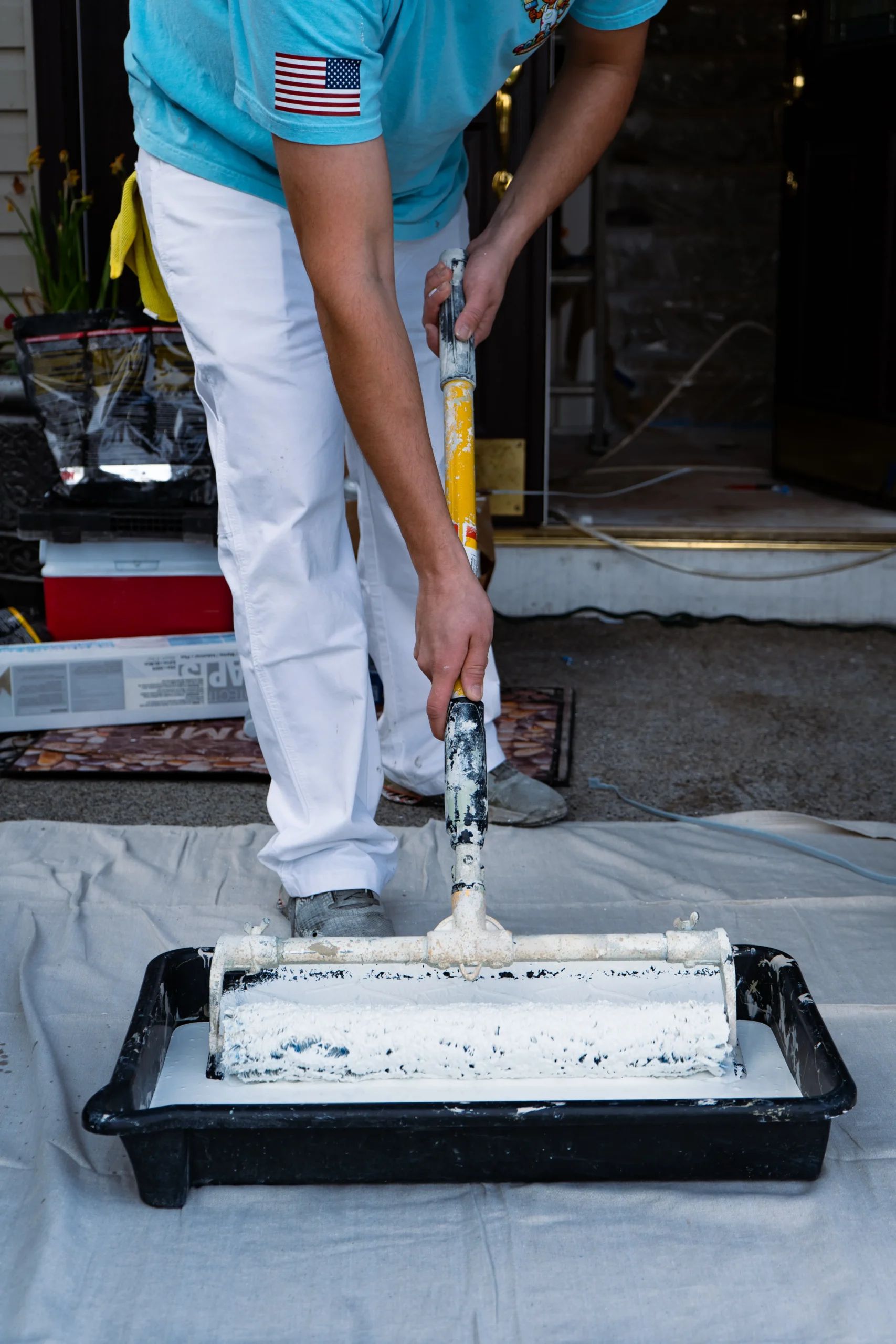 Expert Interior Painting Services A professional painter using a roller to apply white paint, offering interior painting services