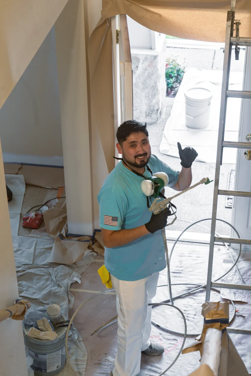 Color Cat Painting crew member giving a thumbs up on a fully protected interior job site