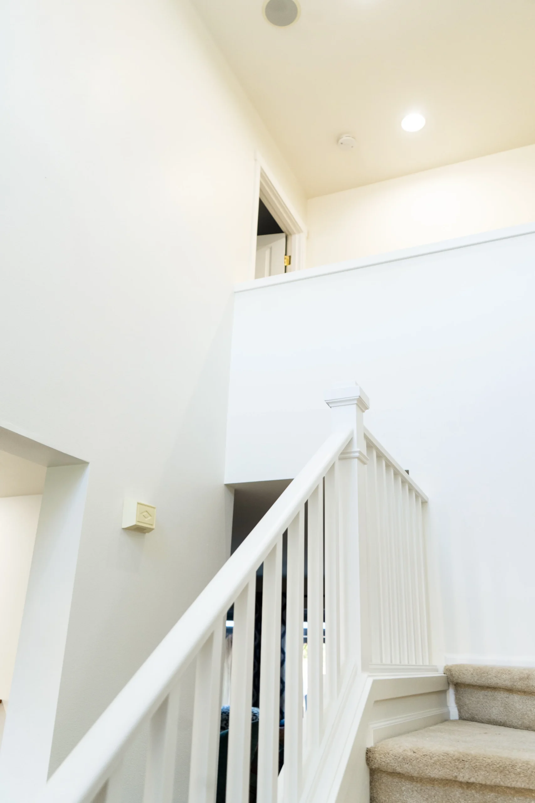 Bright White Interior Staircase and Entryway Painting Freshly painted bright white interior staircase and entryway walls in a residential home.